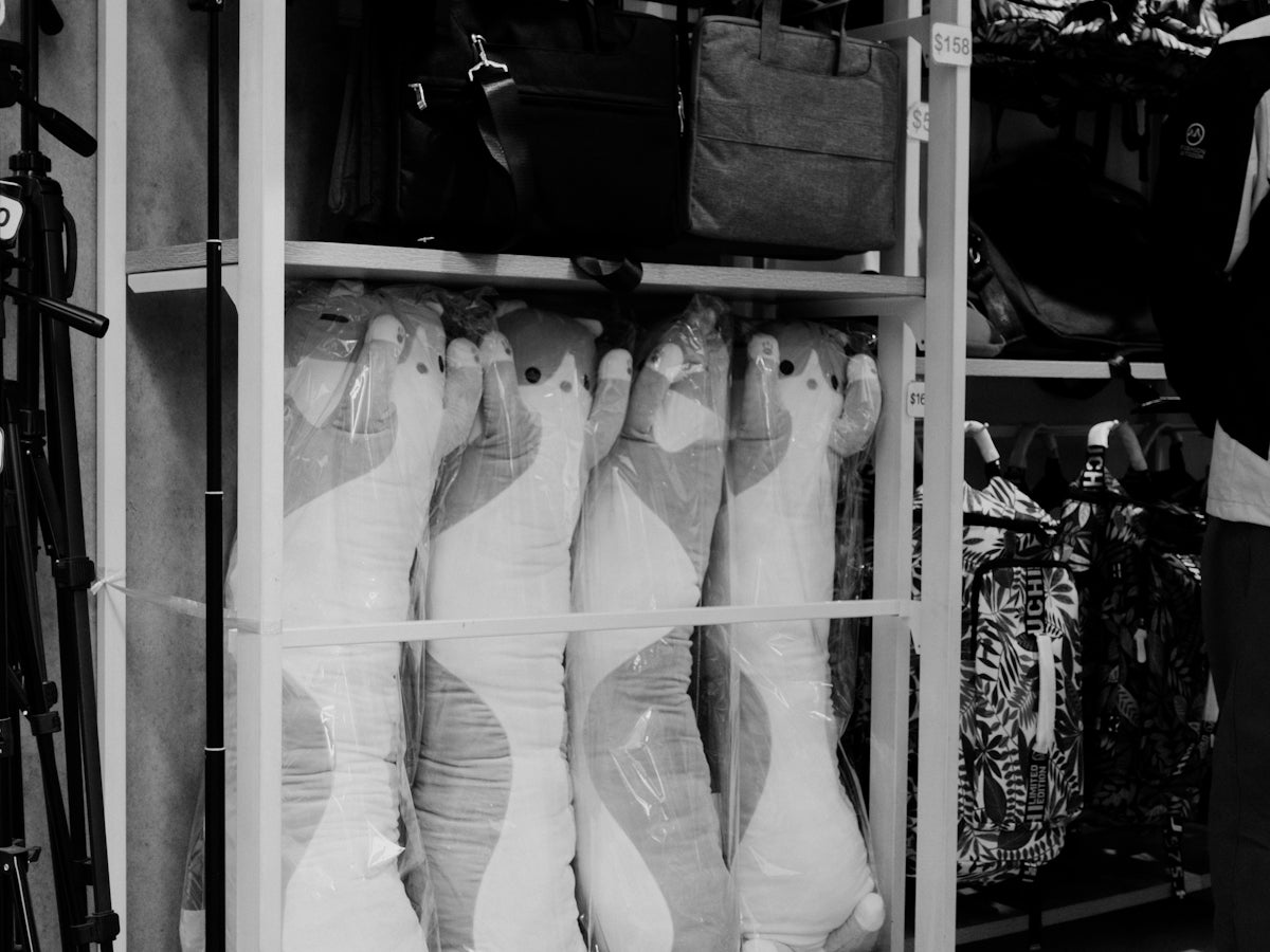 black and white photograph of a person standing in front of a rack of shoes